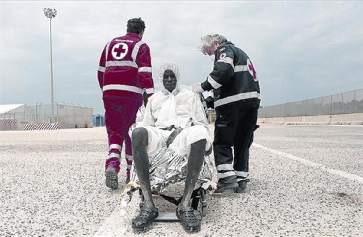 Membres de la Creu Roja atenen un immigrant després de desembarcar a Augusta (Sicília), diumenge passat.