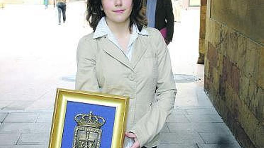 Alexia Constanza Espiño sostiene el escudo de la ciudad de Oviedo.