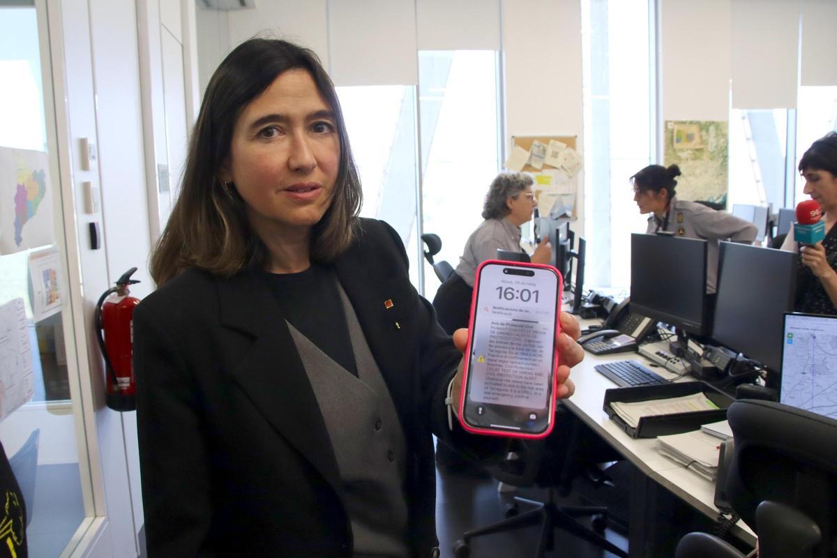 La consellera de Interior, Núria Parlon, enseña el mensaje ES-Alert en su móvil.