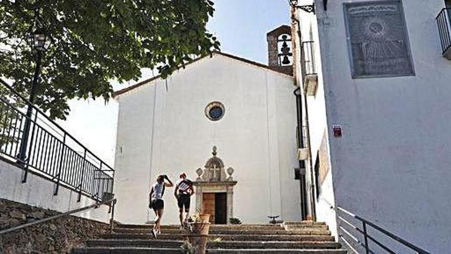 Dues persones pugen les escales que duen al santuari, ahir. A la imatge inferior, la porta de bar tancada.