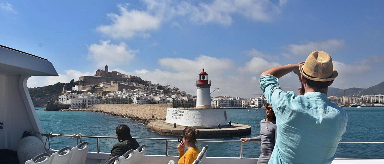 Un pasajero hace una foto durante la salida del puerto de Ibiza de un barco de la línea pitiusa.