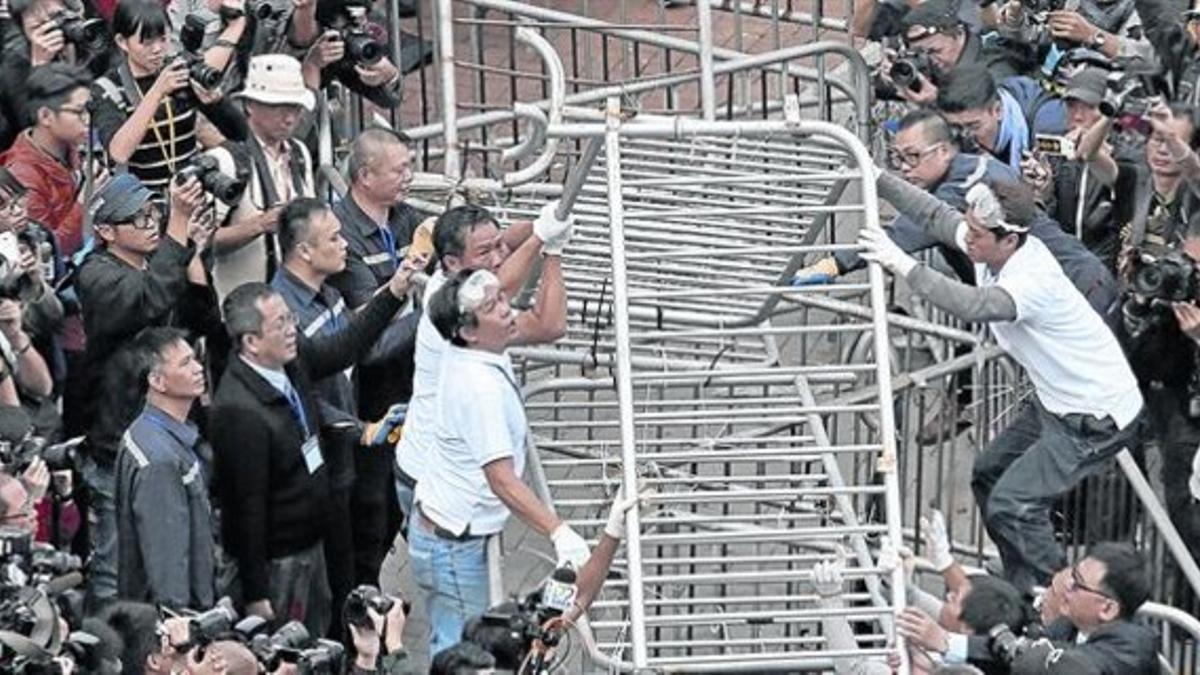 El desmantelamiento 8 Un grupo de trabajadores retira las barricadas cerca de la sede gubernamental de Hong Kong, ayer.