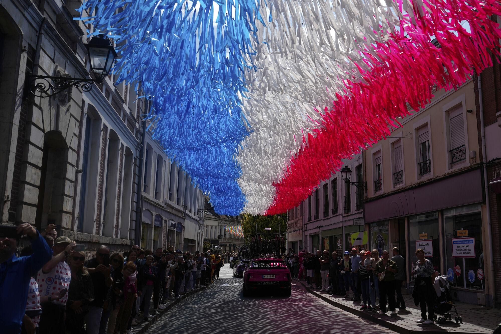 A street is decorated with the colors of the French flag during the third stage of the Tour de France cycling race over 178.3 kilometers (110.8 miles) with start in Valenciennes and finish in Dunkerque, France, Monday, July 7, 2025. (AP Photo/Mosa'ab Elshamy)