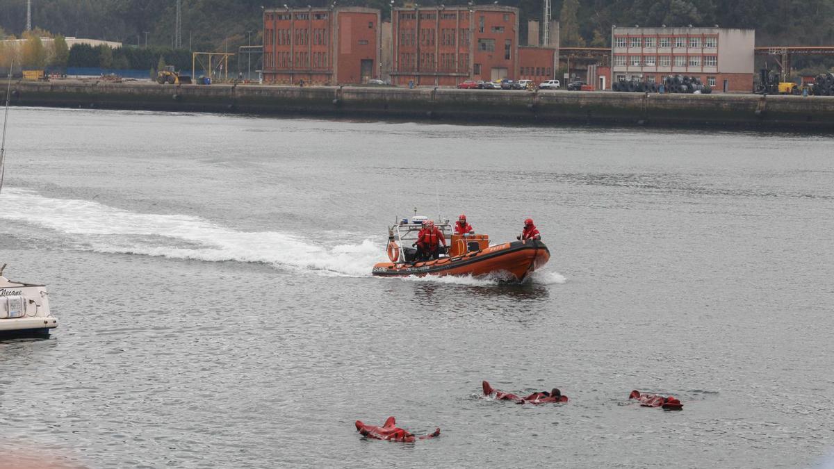 1. Una embarcación de Cruz Roja del Mar se aproxima a la zona donde tres personas flotan a la espera de ser rescatadas como parte del simulacro. 2. Rescate de uno de los náufragos con ayuda de una moto de agua. 3. Los espectadores siguen el operativo desde el paseo de la ría. 4. La embarcación “en apuros”.  | M. V.