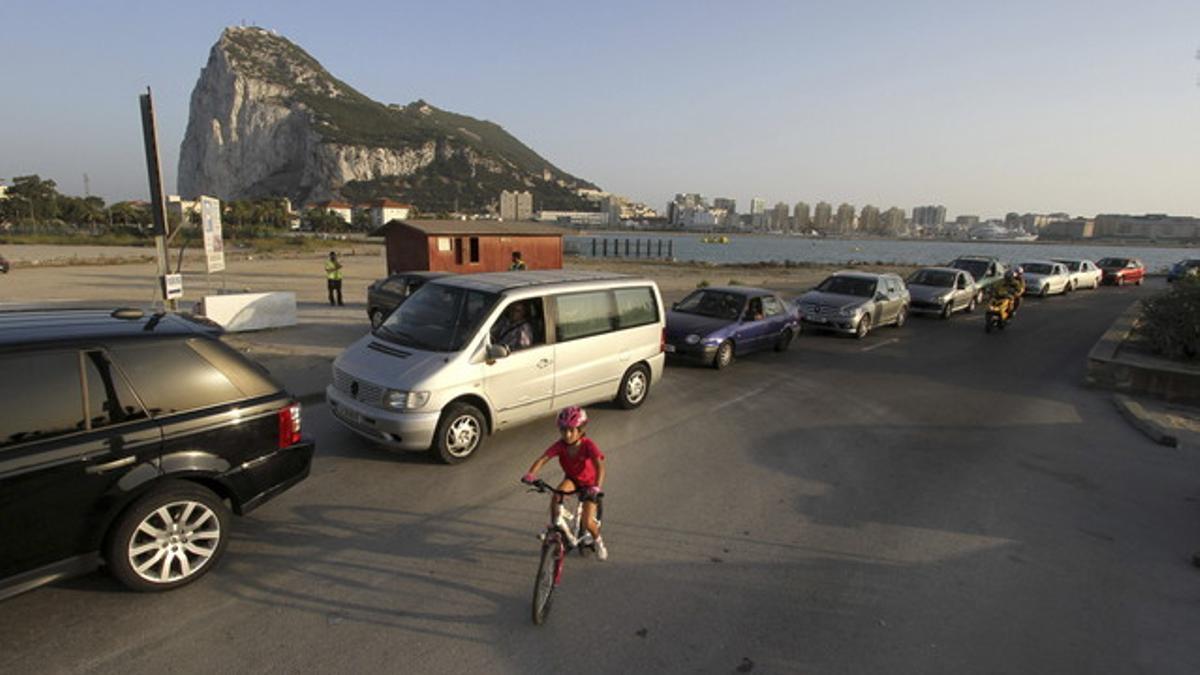 Un niño pasea con su bicicleta junto a una cola de coches para entrar a Gibraltar, en agosto pasado.