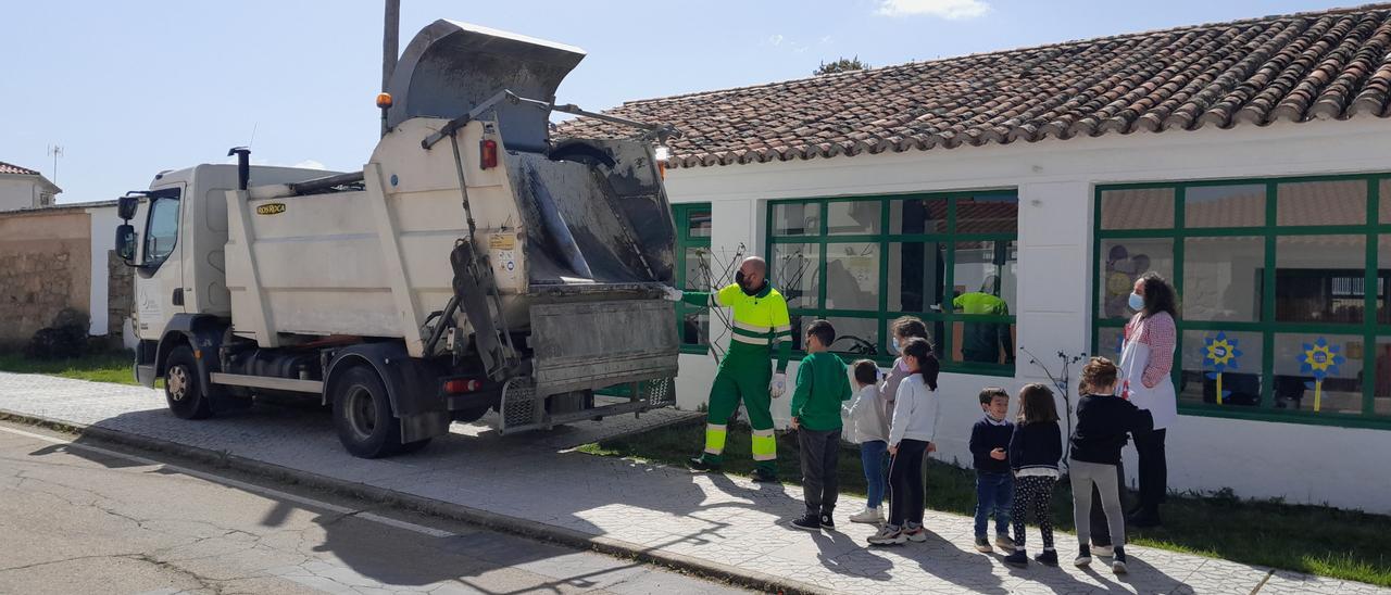 Docente y alumnos del centro educativo San Lorenzo, en Mata de Alcántara, observan un camión de reciclaje.