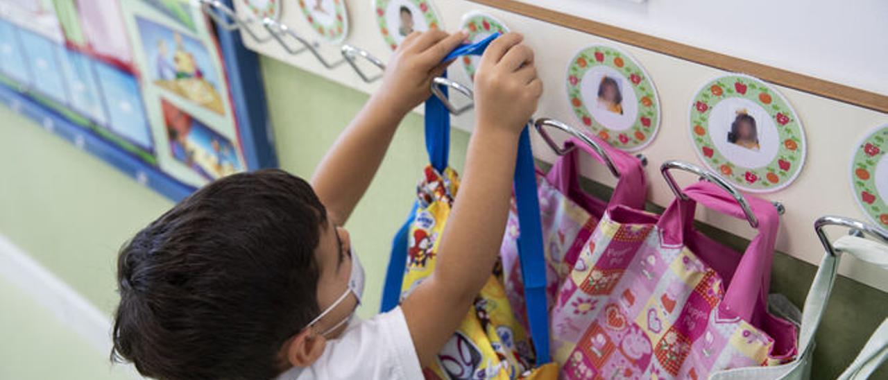 Un niño cuelga su mochila en un aula de Infantil.