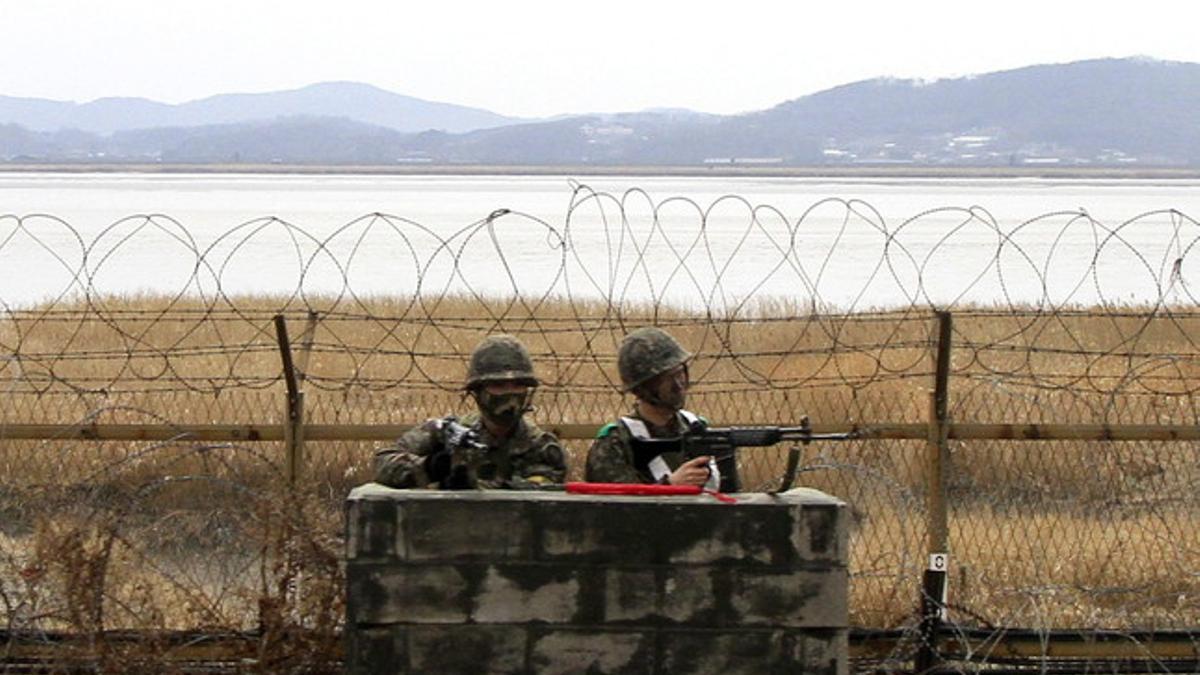 Dos soldados surcoreanos vigilan tras una barricada cerca de la zona desmilitarizada en Paju, el pasado jueves.