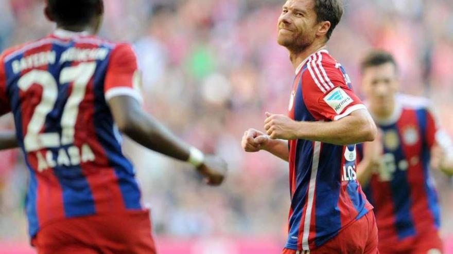 Xabi Alonso sonríe a su compañero Alaba durante un partido con el Bayern de Múnich. // Efe