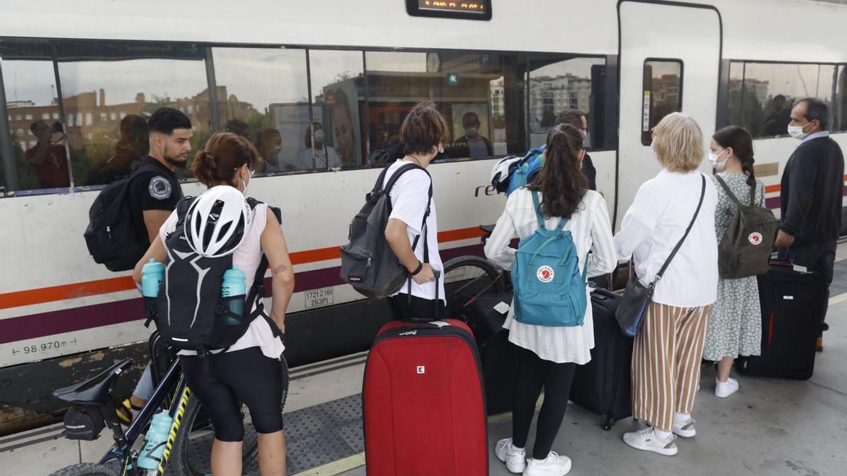 Passatgers pujant a un tren de Girona, ahir al migdia.  | ANIOL RESCLOSA