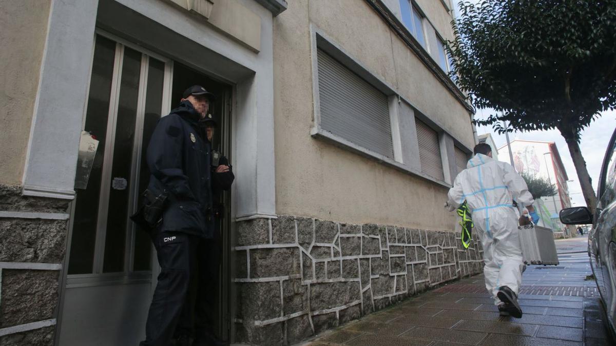 La policía científica deja el edificio custodiado por agentes de la Nacional.