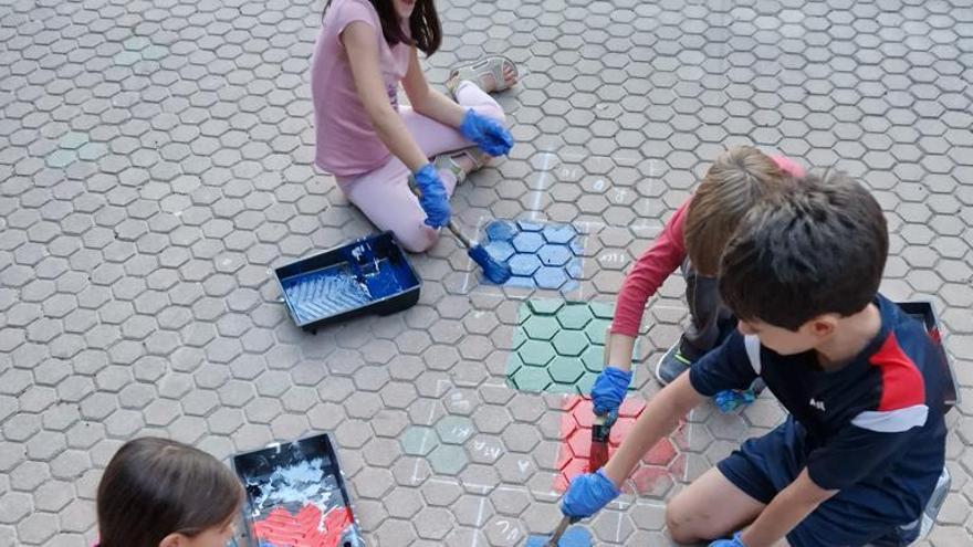 Varios niños pintan una rayuela.