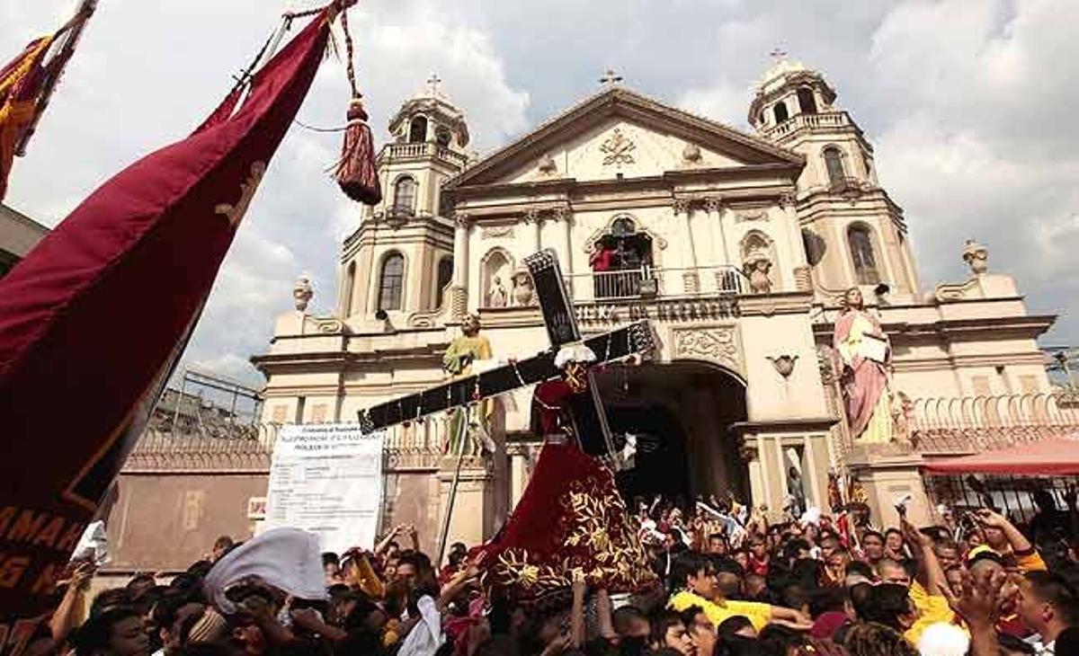 Devots filipins acompanyen en processó l’estàtua del Crist Negre després de sortir de l’església de Quiapo, al centre de Manila (Filipines).