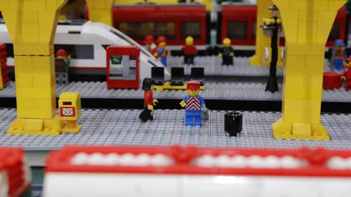 Lego-Männchen warten am Bahnhof auf den Zug