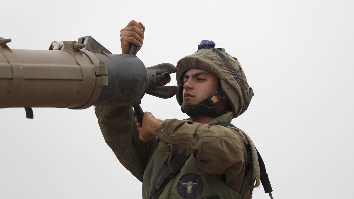 Un soldado israelí inspecciona equipamiento militar, mientras permanece cerca de la frontera con Gaza, al sur de Israel.