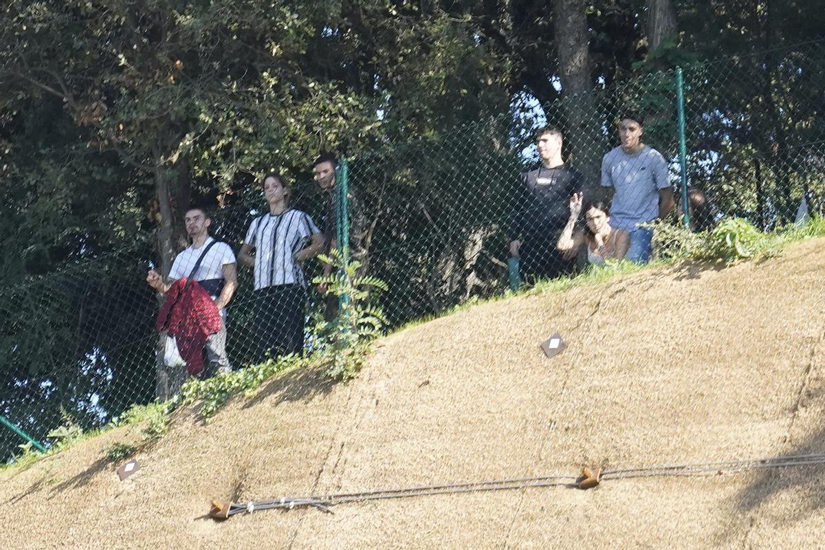 Aficionats veient el partit des de darrere una tanca de fora l'estadi