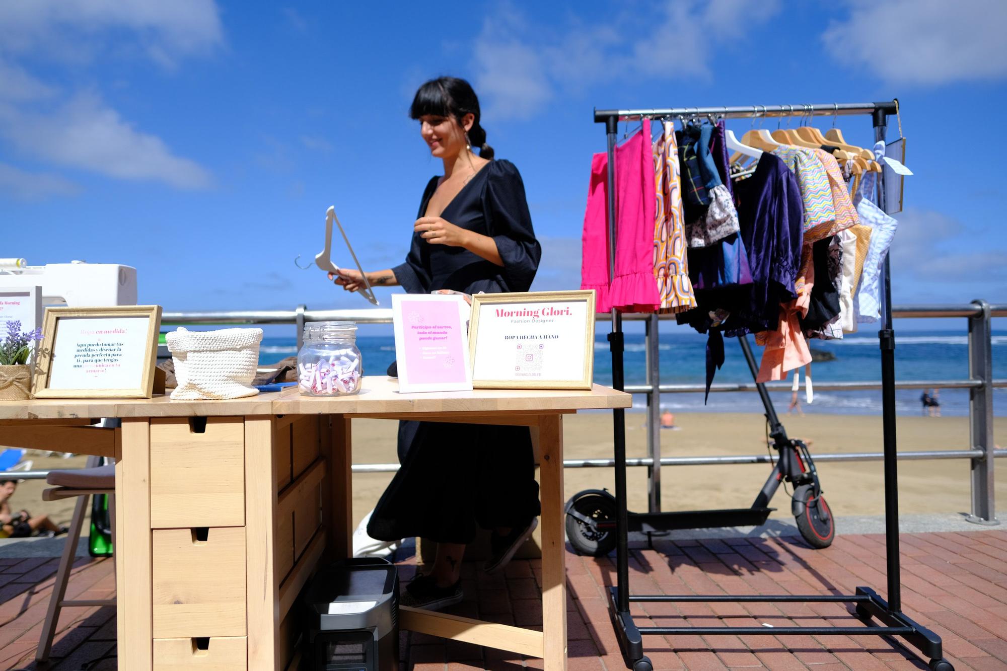 La diseñadora Gloria Mangolini cose con su máquina en la playa de Las Canteras