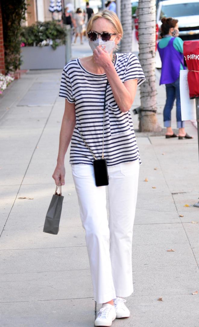 Sharon Stone con camiseta a rayas, pantalón blanco y zapatillas