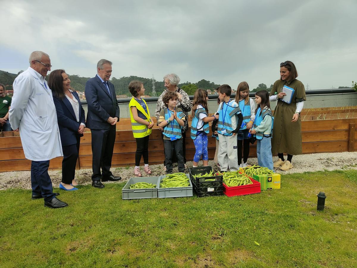 Entrega de la cosecha a la hermana Guadalupe, en el centro, hablando con los niños, en presencia del conselleiro, la delegada de la Xunta en Vigo y el gerente del área.