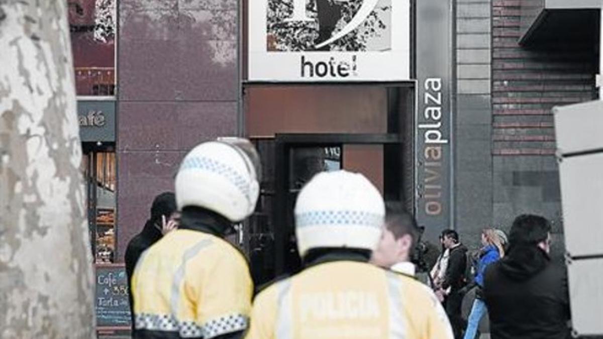 Dos agentes de la Guardia Urbana, ayer, ante la fachada del Hotel Olivia Plaza, en la plaza de Catalunya.