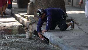 Decenas de caraqueños decidieron recoger agua del alcantarillado de la ciudad y del contaminado rio Guaire debido a la imposibilidad de recibir agua en los hogares por causa del apagon que afecta al pais desde el pasado jueves. 