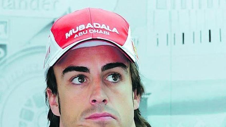 Fernando Alonso espera en el box de Ferrari, tras la carrera, la resolución sobre el adelantamiento de Schumacher.