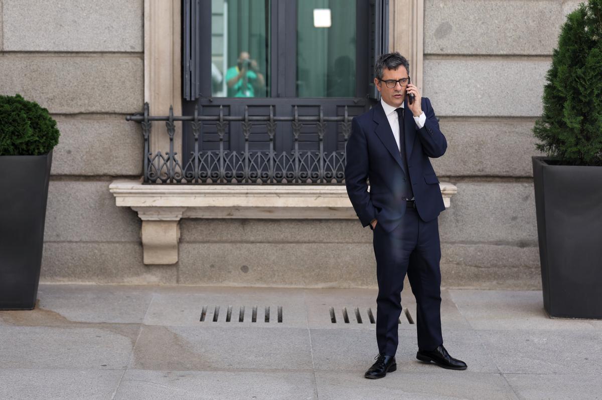 El ministro Félix Bolaños habla por teléfono en el patio del Congreso antes de intervenir en defensa de la Ley de Memoria Democrática