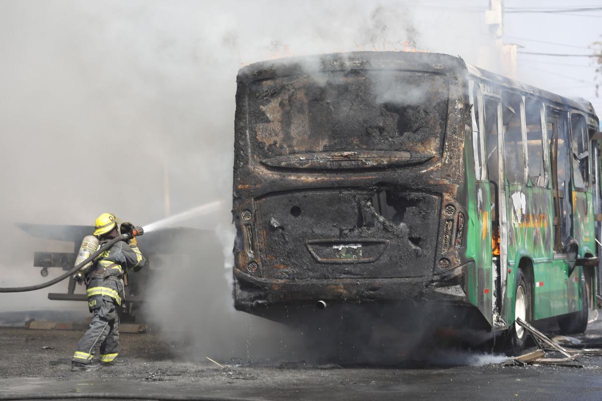 Un integrante del Cuerpo de Bomberos de Guadalajara intenta apagar un vehículo incendiado este domingo.