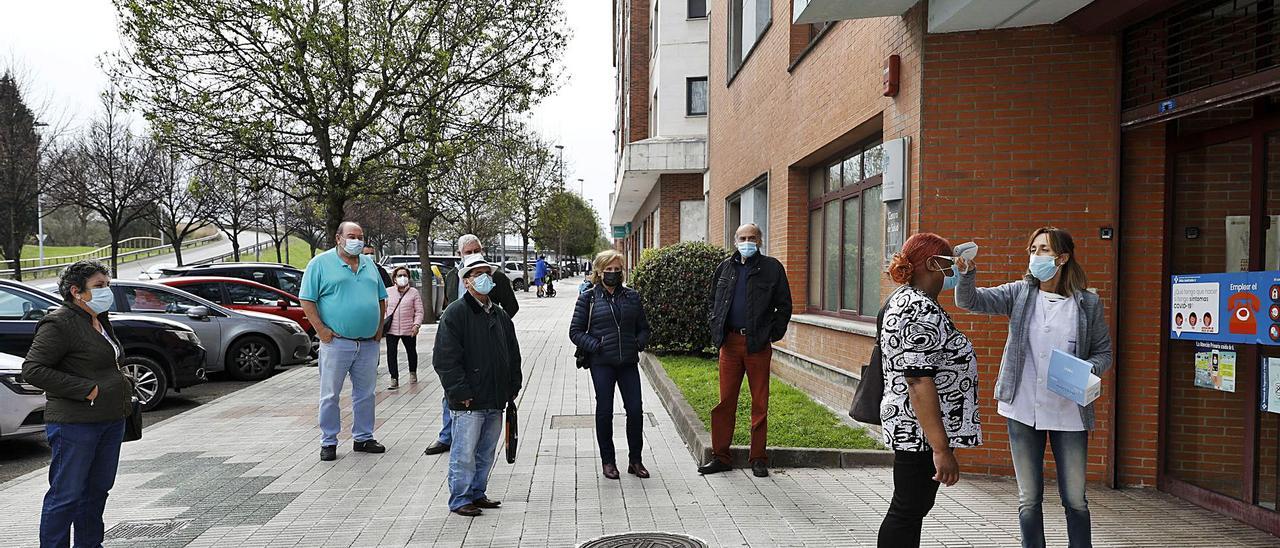 Cola de personas menores de 66 años esperando a vacunarse en el centro de salud del Natahoyo (Gijón). | Marcos León