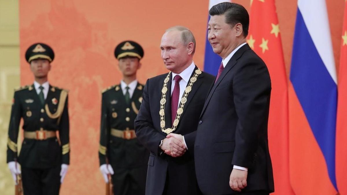 El presidente chino Xi Jinping estrecha la mano de Vladímir Putin, después de imponer la Medalla de la Amistad durante una ceremonia en Pekín.