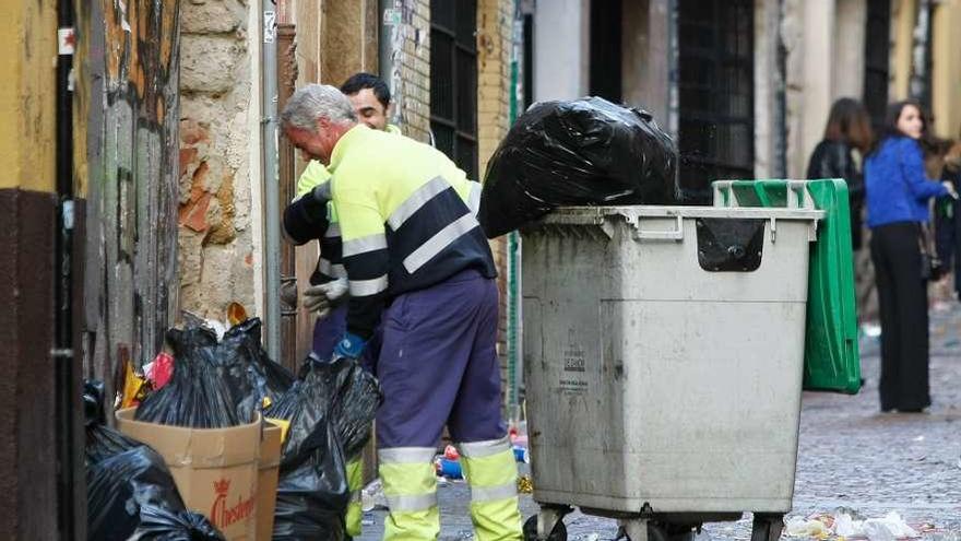 Tabajadores de la limpieza de la capital recogen residuos en una de las calles