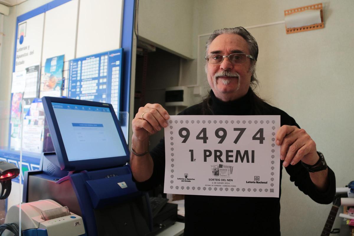 El propietario de la administración de lotería de Corbera de Ebro, Francesc Cortiella, muestra el número ganador vendido en el sorteo de Reyes