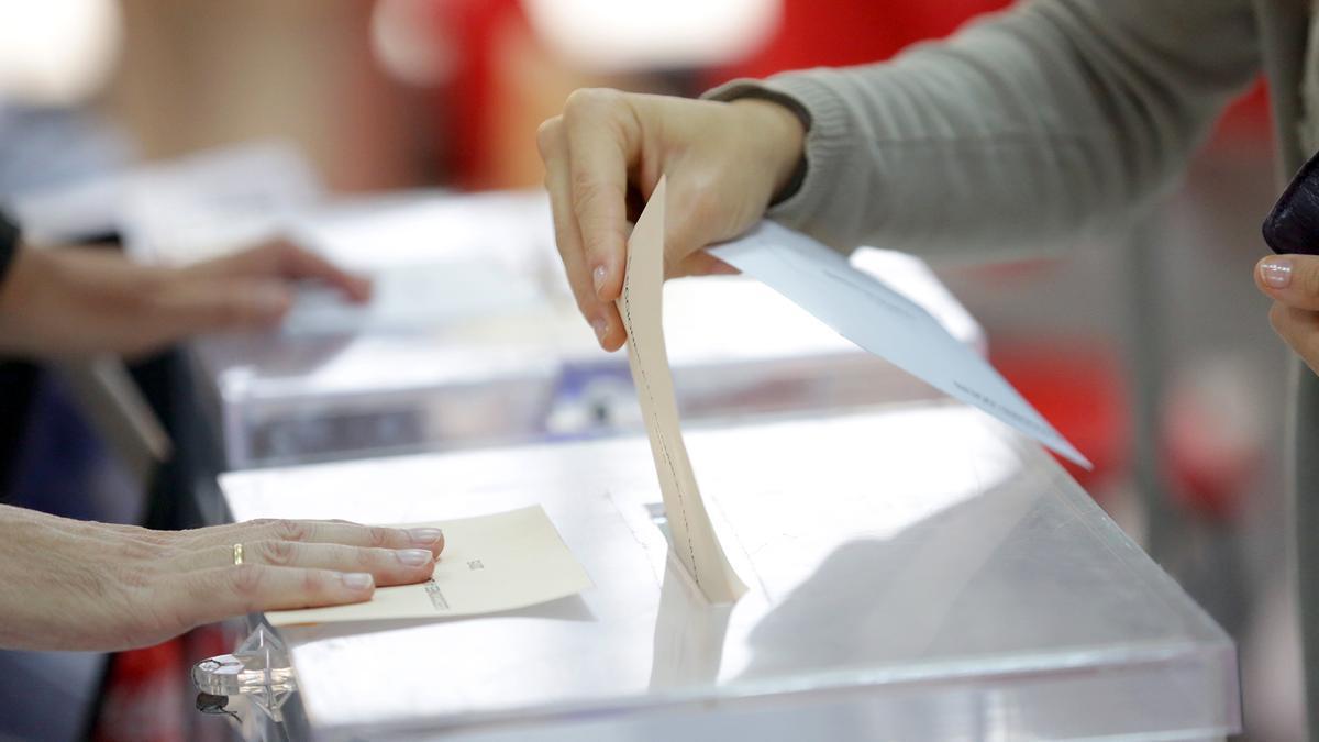 Un ciudadano deposita una papeleta electoral en una urna.