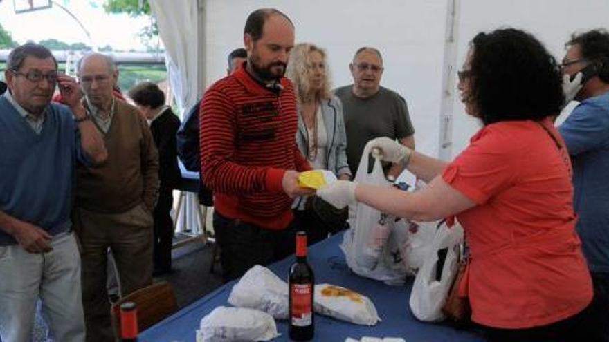 Vecinos de Villamiana recogen el bollo y el vino durante las fiestas.