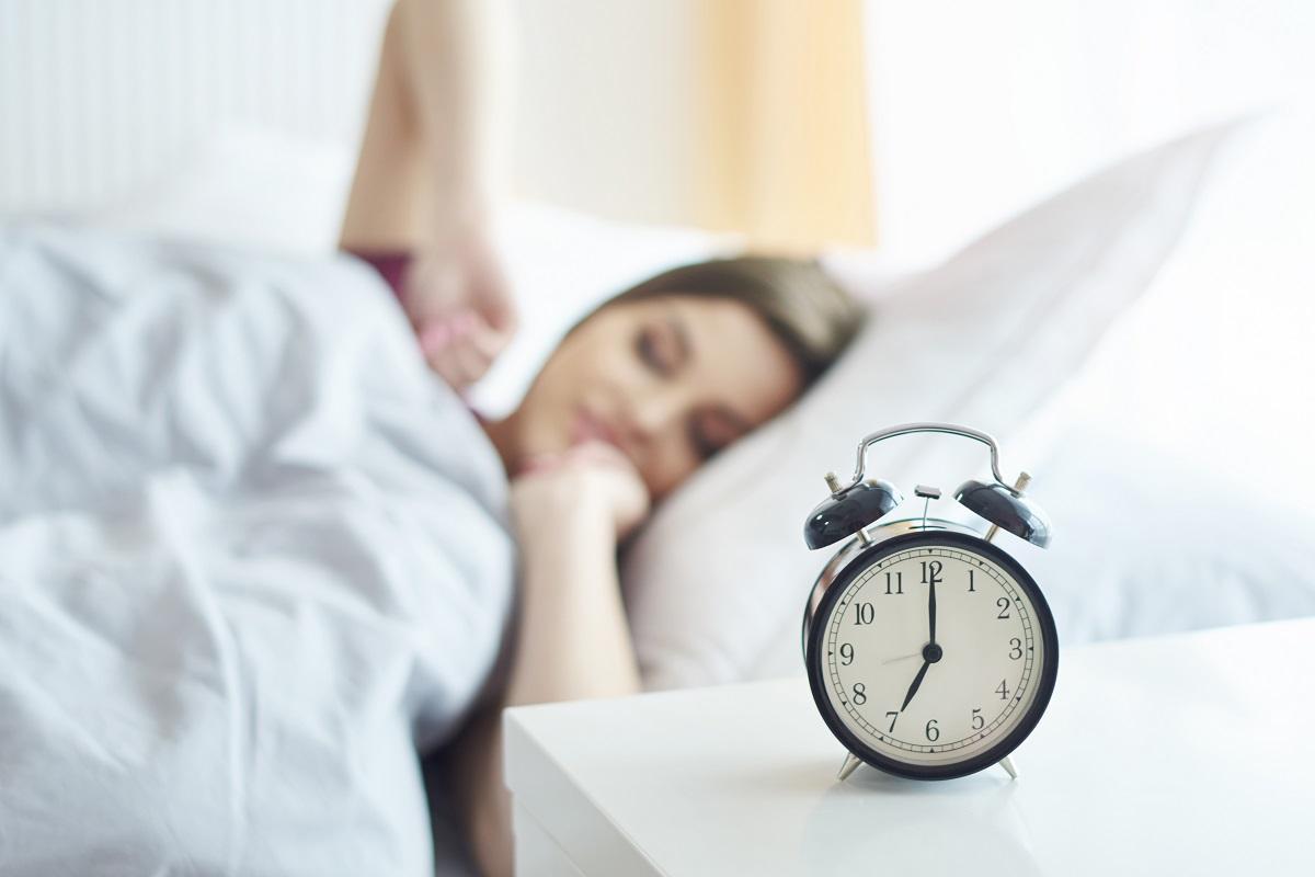 Una mujer se despereza en la cama.