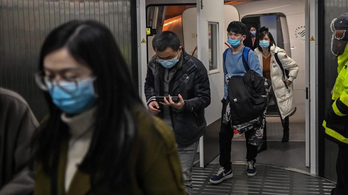 Passengers wearing protective facemasks as a preventive measure against the Covid-19 (the novel coronavirus) leave the plane upon their arrival at the Tianhe International Airport in Wuhan  in China s central Hubei province  on January 27  2021  (Photo by Hector RETAMAL   AFP)