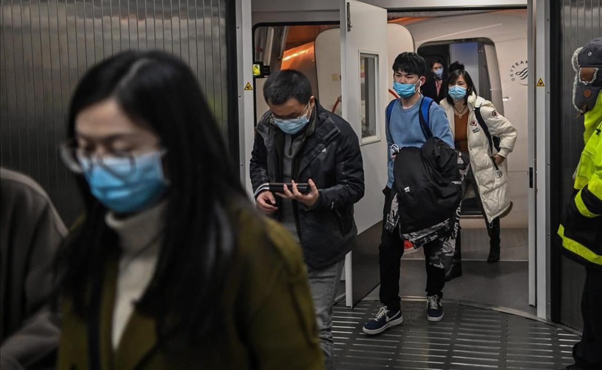 Passengers wearing protective facemasks as a preventive measure against the Covid-19 (the novel coronavirus) leave the plane upon their arrival at the Tianhe International Airport in Wuhan in China s central Hubei province on January 27 2021 (Photo by Hector RETAMAL AFP)