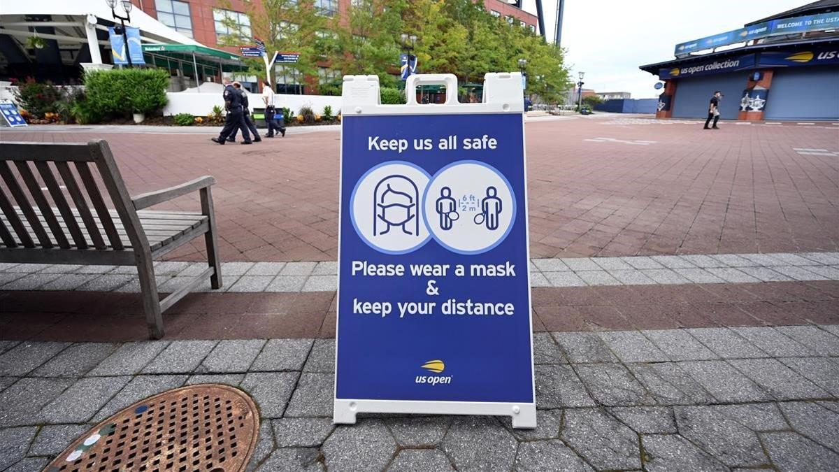 Una señal urge a mantener la distancia social en las instalaciones donde se celebra el US Open.