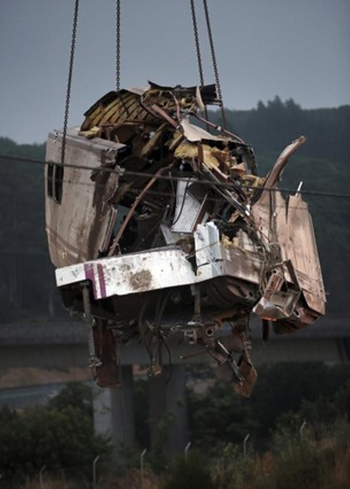 Una grua càrrega un de dels vagons del tren sinistrat.