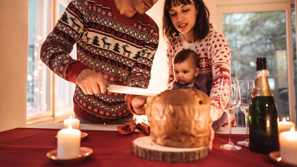 Familia comiendo panettone con jerseys de Navidad