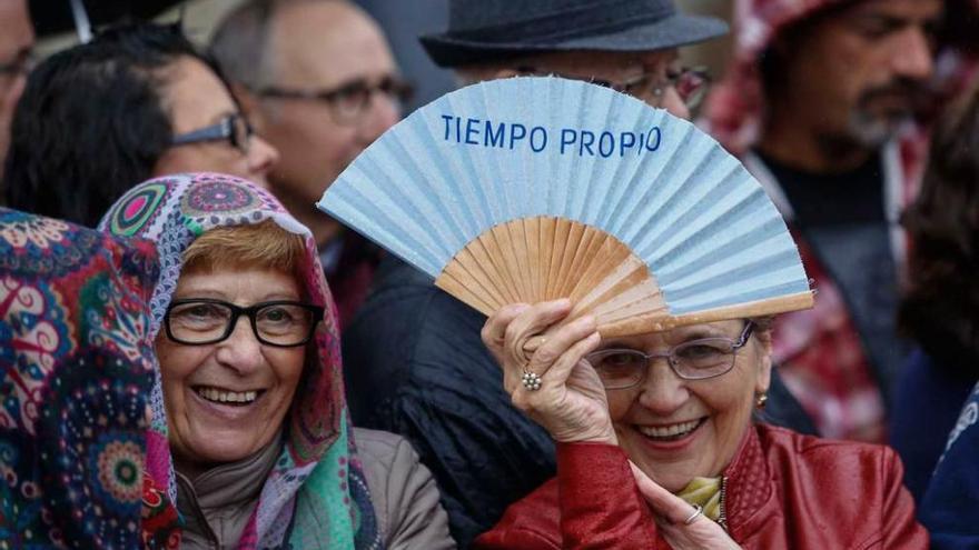 Los Reyes y Marcos Niño observan el trabajo de Irene Villar al telar. Abajo, dos vecinas y Patricia Suárez, con una foto firmada por el Monarca.