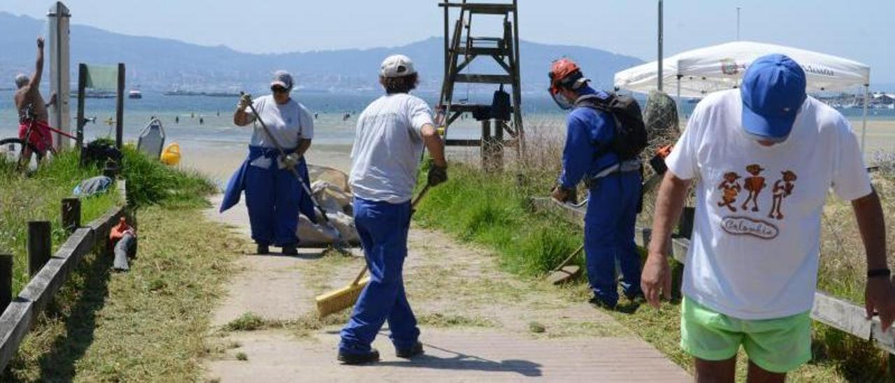 La brigada municipal, ayer, limpiando los accesos a la concurrida playa de Meira. | GONZALO NÚÑEZ