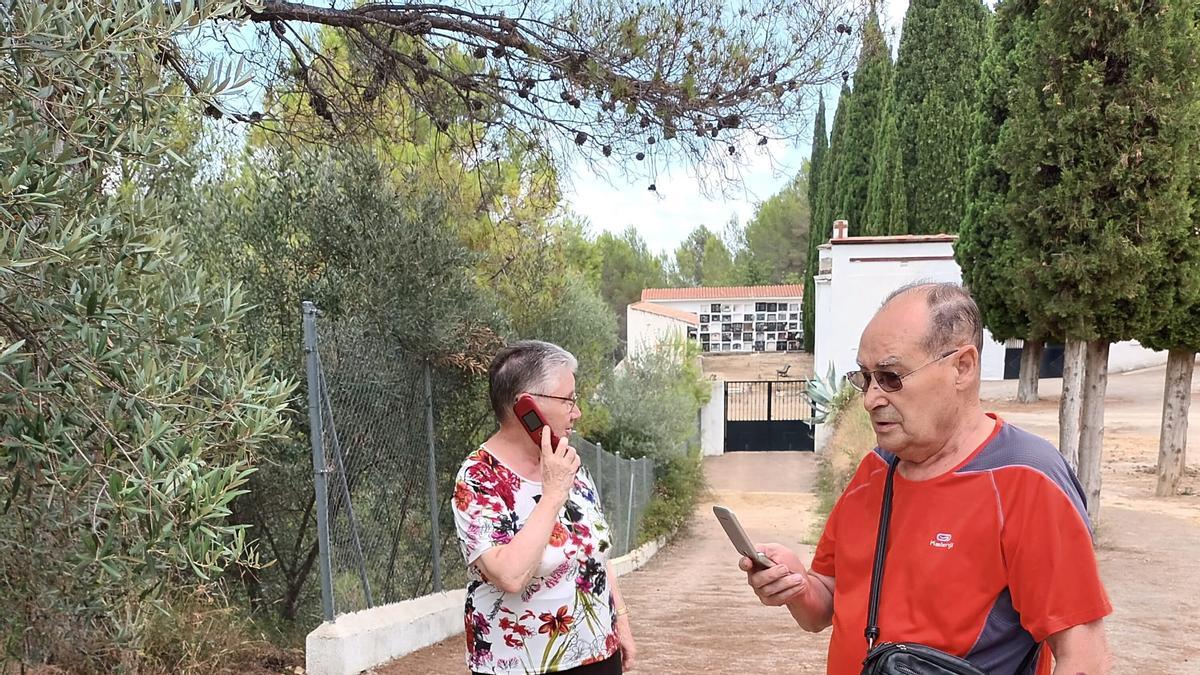 Juana Ávila con su marido en la entrada del cementerio de Suera hasta donde tuvieron que subir para coger cobertura.