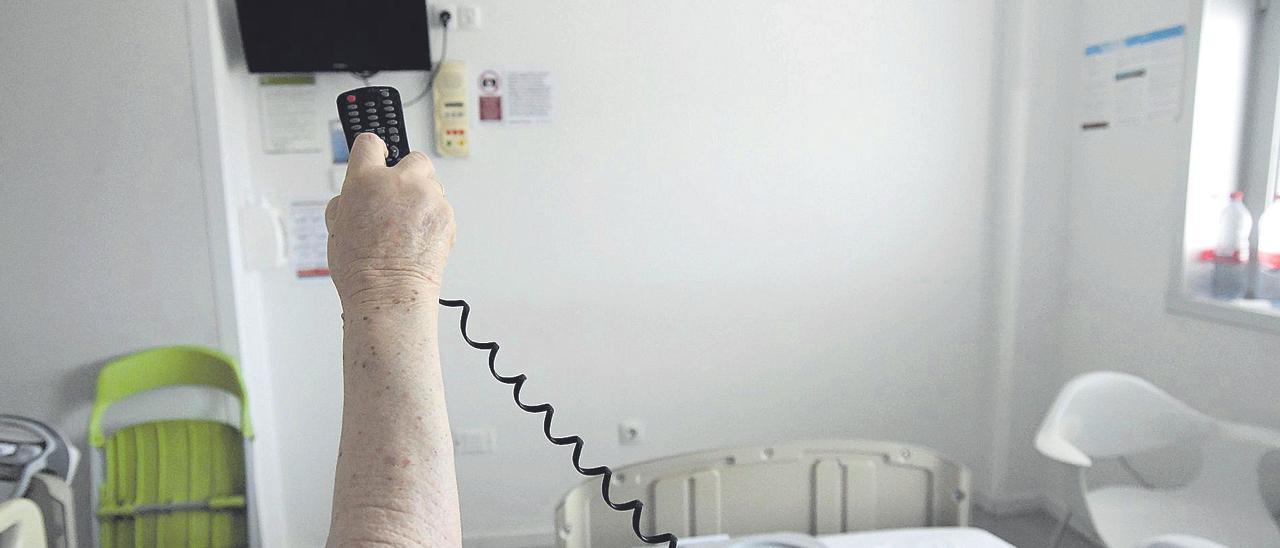 Una paciente enciende la televisión de su habitación en el Hospital Reina Sofía de Murcia.