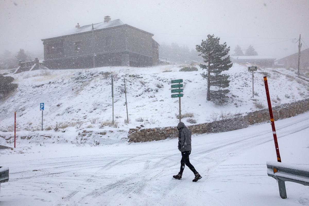 Un hombre camina por la nieve en el Puerto de Navacerrada.