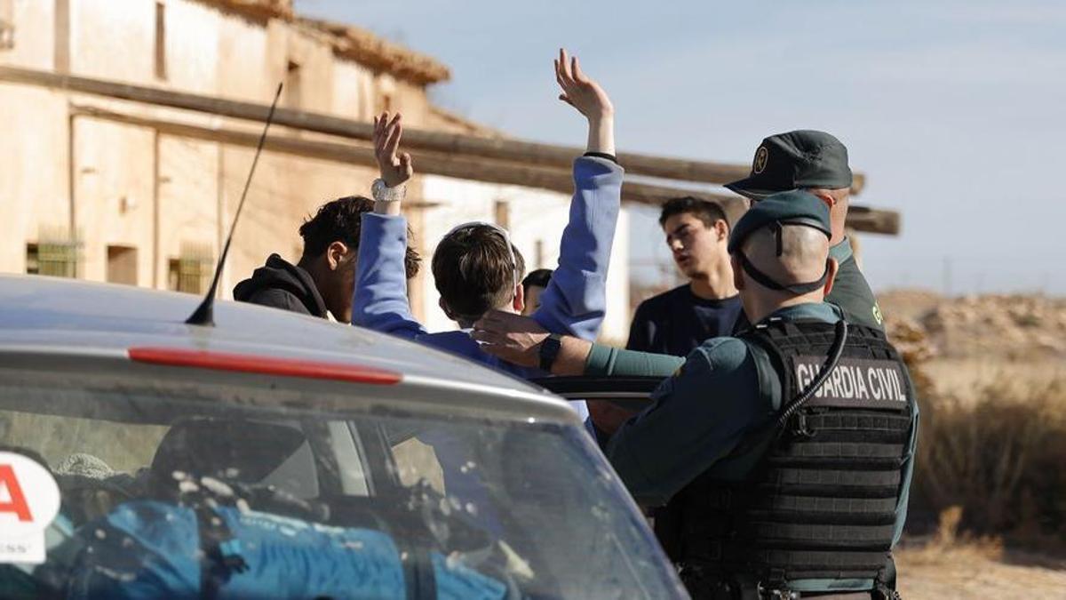 Agentes de la Guardia Civil identificando a uno de los asistentes a la rave.