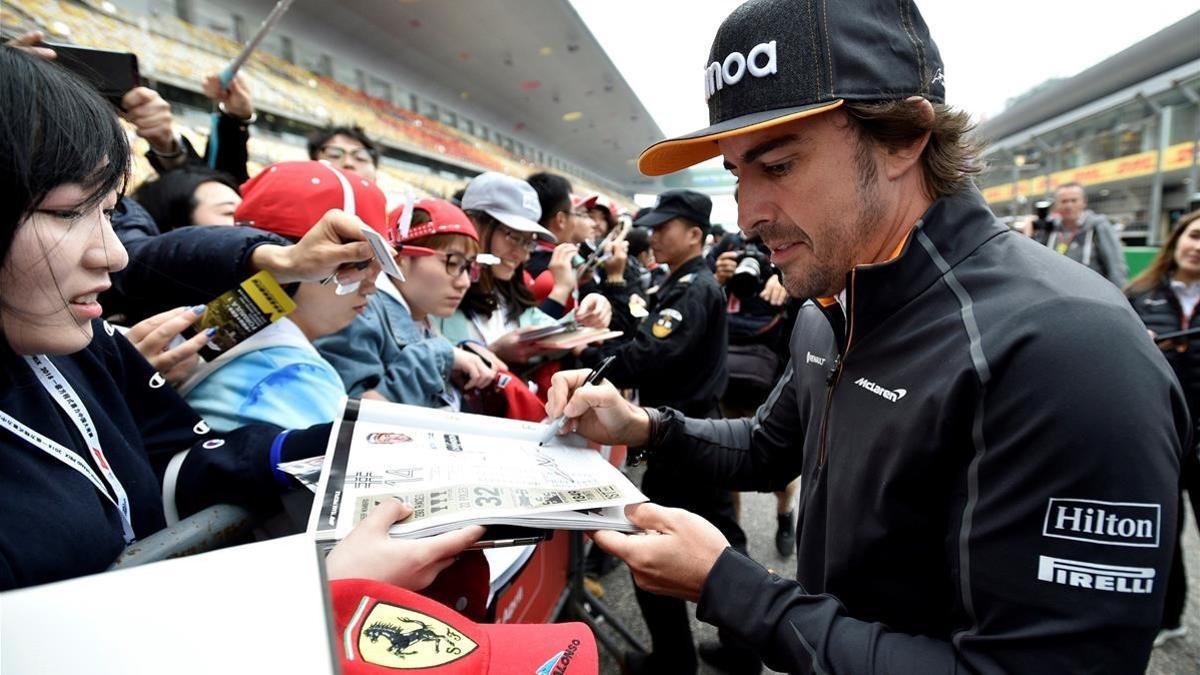 Fernando Alonso firma autógrafos en el circuito de Shanghai.