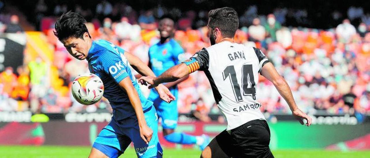 Kang In Lee lucha con  
Gayà por el  balón el 
sábado en Mestalla. |  EFE