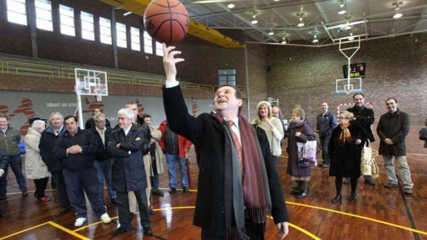 Abel Caballero hace girar un balón de baloncesto en presencia de varios ediles y vecinos.  // R. Grobas