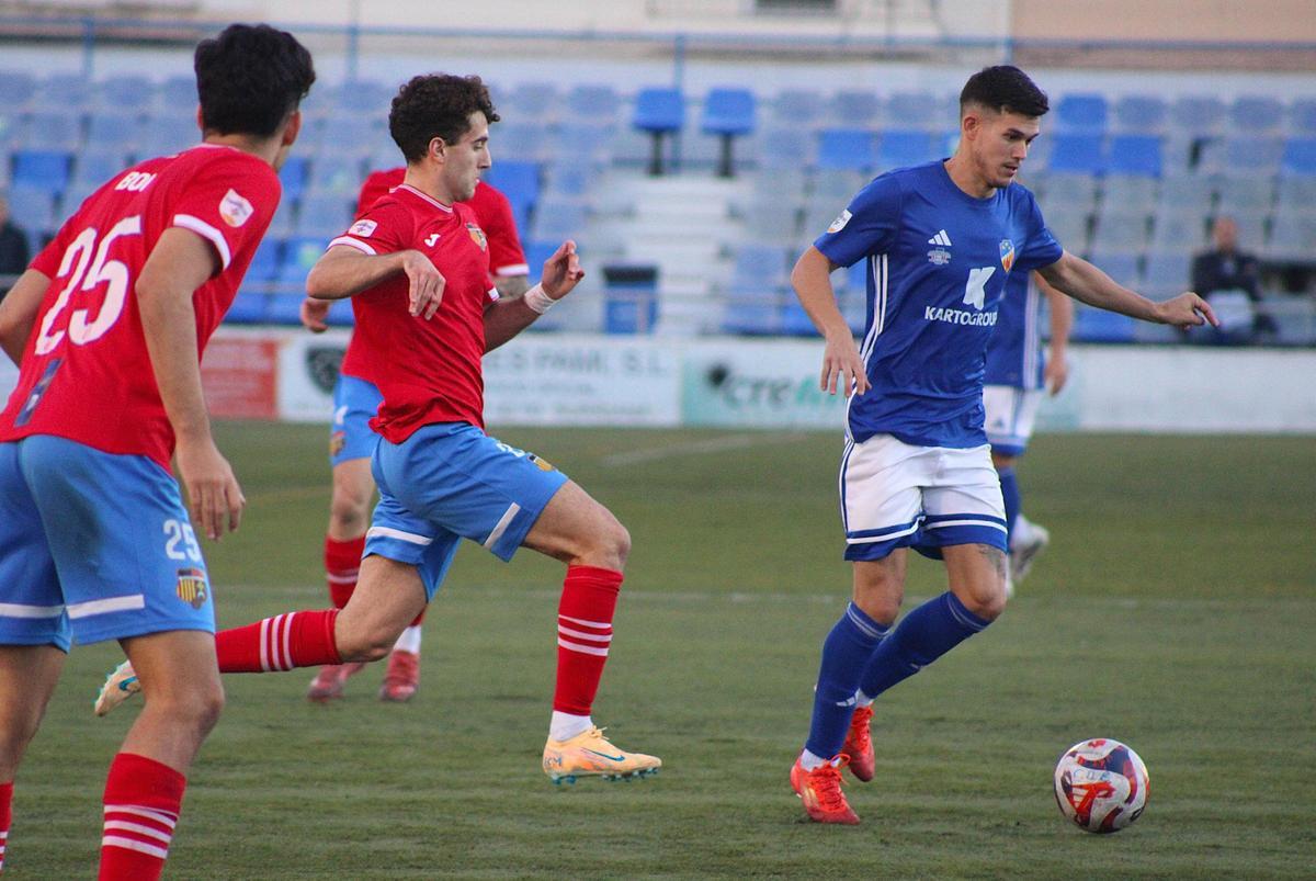 Juan López controla el balón ante la atenta mirada del buen extremo zurdo Charly Ferrer.